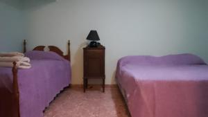 1 dormitorio con 2 camas con sábanas moradas y vestidor en Corazón Malbec en Mendoza