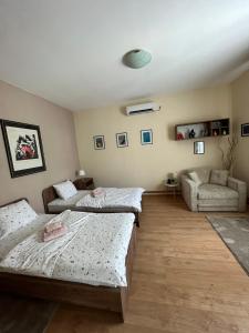 sala de estar con 2 camas y sofá en Guest House A'storia en Ruma