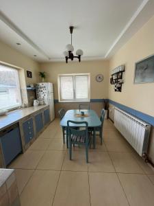 a kitchen and dining room with a table and chairs at Guest House A'storia in Ruma