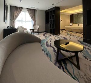 a hotel room with a couch and a bedroom at Al Wateen Hotel in AlUla