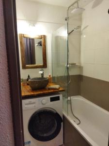 Antarès Location Avoriaz في أفورياز: حمام مع غسالة وحوض استحمام