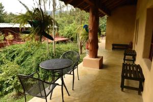 a patio with a table and chairs and a bird at Cabañas Sierra Gorda in Jalpan de Serra
