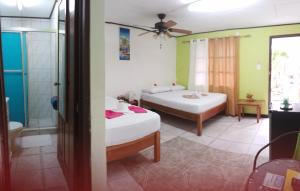 ein Schlafzimmer mit 2 Betten und ein Badezimmer in der Unterkunft Cabinas Smith in Cahuita