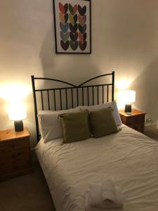 a bedroom with a bed with two night stands and two lamps at Hillview, Ground floor apartment, Largs in Largs