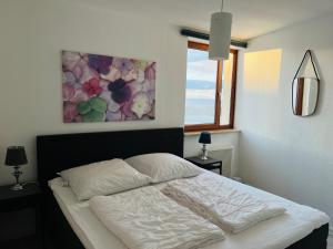un letto in una camera da letto con un dipinto sul muro di Wasserblick, in 3 Min am Strand a Heiligenhafen