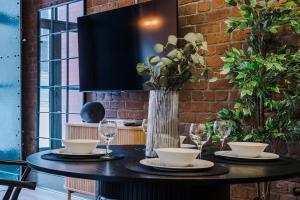 een tafel met borden en glazen en een vaas met bloemen bij Host & Stay - Bands Warehouse IV in Liverpool