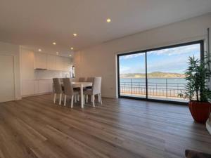 uma sala de jantar com uma mesa e vista para o oceano em Apartamento em frente à Praia em São Martinho do Porto