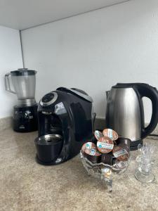 Casa na Grande Florianopolis في باليوسا: محمصة وآلة صنع القهوة على منضدة مع صحن من الشوكولاتة