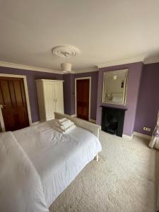 1 dormitorio con cama blanca y espejo en Taylors Hill Luxury Guest House, en Galway