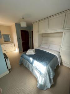 1 dormitorio con 1 cama grande con manta azul en Taylors Hill Luxury Guest House en Galway