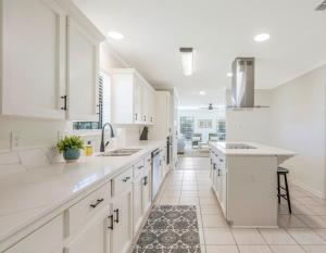 uma cozinha com armários brancos e piso em azulejo em Updated & centrally located 3 Bed em Lafayette