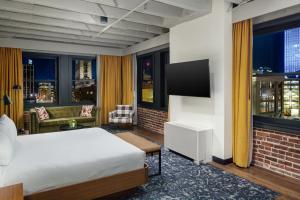 Cette chambre comprend un lit et une télévision à écran plat. dans l'établissement Hotel Indigo - Omaha Downtown, an IHG Hotel, à Omaha