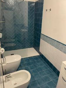 uma casa de banho em azulejos azuis com um WC e um chuveiro em Agenzia Isotur La Magnolia em Ponza