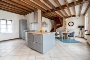 a kitchen with wooden ceilings and a table with chairs at Gîte La Belle Aventure avec piscine et jacuzzi in Mosnes
