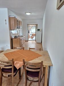 a kitchen and dining room with a wooden table and chairs at Chalupa u Šobrů in Kout na Šumavě