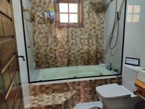 a bathroom with a tub and a toilet at Chácara Recanto da Mata in Cunha