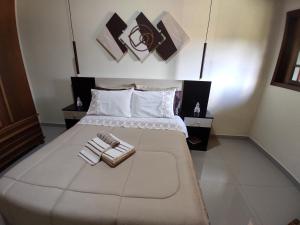 a bedroom with a large bed with two towels on it at Chácara Recanto da Mata in Cunha