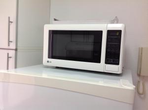 un four micro-ondes installé sur une étagère dans une cuisine dans l'établissement Departamento Olivos-zona puerto, à Olivos