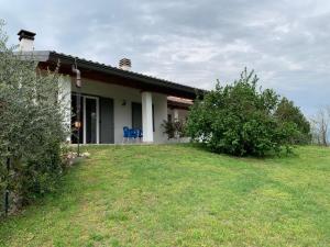 a small house with a lawn in front of it at Casa Vacanze AL CAPRIANO appartamento Mora in Cantello