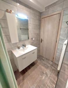 a bathroom with a white sink and a mirror at Myrsini’s sea view apartment in Nea Peramos +37 photos