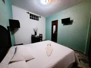 1 dormitorio con 1 cama con manta blanca en Hotel Santa Maria, en Panajachel