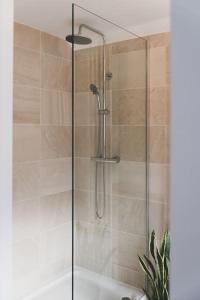 um chuveiro com uma porta de vidro na casa de banho em Architect designed spacious five bed house by sea em Seasalter