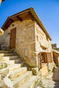 um edifício de pedra com uma porta e algumas escadas em A Casiña dos Canastros 