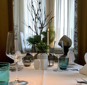 un tavolo con bicchieri da vino e una candela sopra di Thuns Dorfkrug a Werdohl