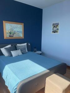 1 dormitorio azul con 1 cama con pared azul en Reunion in Greece Villa, en Drafí