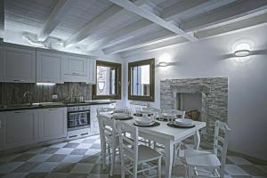 a white kitchen with a white table and chairs at Palazzo Giacchina in Sottomarina