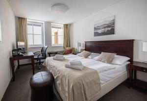 a bedroom with a large bed with two towels on it at Hotel Petrovy kameny in Karlova Studánka