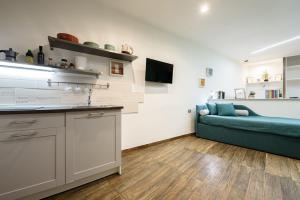 a kitchen and a living room with a blue couch at Loft by B&B Università in Naples