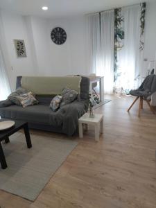 salon z kanapą i drewnianą podłogą w obiekcie Casa en piedra (Stone House) w mieście Porriño