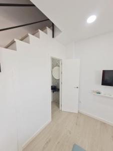 salon z białymi ścianami i schodami w obiekcie Gemini Conil w mieście Conil de la Frontera
