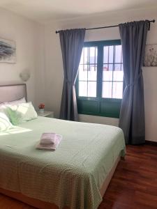Un dormitorio con una cama grande y una ventana en RELAX & POOL NEXT TO THE BEACH APT en Puerto del Carmen
