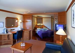 een hotelkamer met een bed en een televisie bij Quality Hotel Olavsgaard in Skjetten