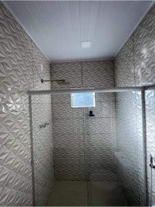 a bathroom with a shower with a glass door at Chalé encontro dos rios in Nova Friburgo