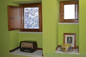 Habitación verde con TV y microondas. en Casa Borgo Marco e Cristina en Spoleto