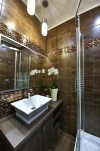 a bathroom with a sink and a shower at Royal Apartments Hotel Kecskemét in Kecskemét