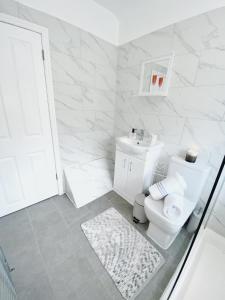 Baño blanco con aseo y lavamanos en Luxurious family home in West Midlands en Northfield