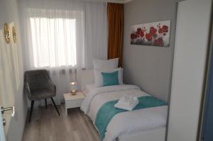 a small bedroom with a bed and a chair at Cozy house with garden in Kaufbeuren