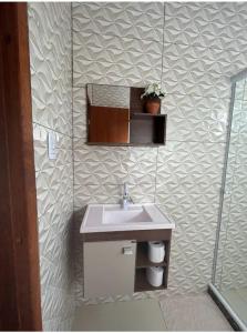 a bathroom with a sink and a mirror at Chalé encontro dos rios in Nova Friburgo