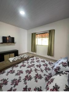 a bedroom with a large bed and a window at Chalé encontro dos rios in Nova Friburgo