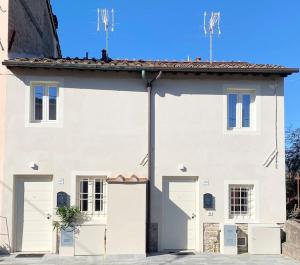 un gran edificio blanco con dos puertas de garaje en Viaggiare Smart [Wi-fi, TV HD, Spazio di lavoro, Parcheggio gratuito nella struttura,], en Capannori