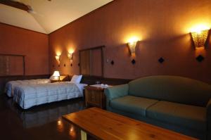 a hotel room with a bed and a couch at Resonate Club Kuju in Taketa