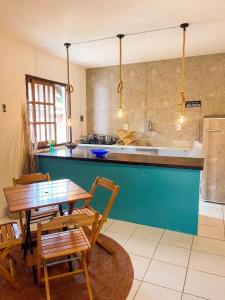 eine Küche mit einem Tisch, Stühlen und einer Theke in der Unterkunft Casa Mar in Praia do Forte
