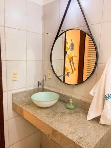 bagno con lavabo a ciotola e specchio di Casa Mar a Praia do Forte