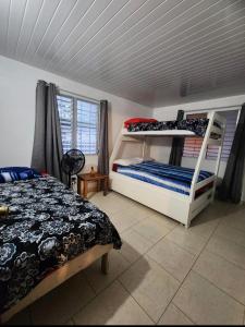 1 dormitorio con 2 literas y ventana en Casa de Campo, frente a la playa Skybluebyguanche en Colón