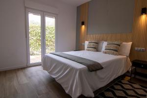 a bedroom with a large white bed and a window at La Lagunilla Golf in Candeleda