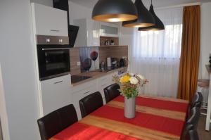 a kitchen with a table with a vase of flowers on it at Cozy house with garden in Kaufbeuren